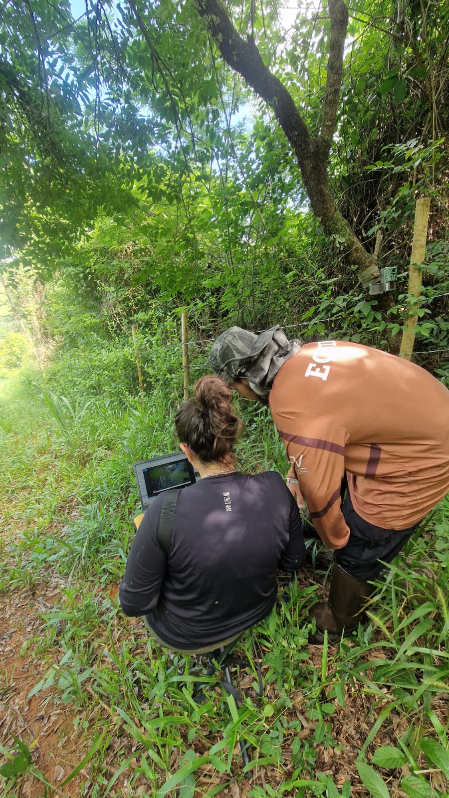 Bárbara e Gabriel Buffe triando os registros de uma câmera trap no fragmento